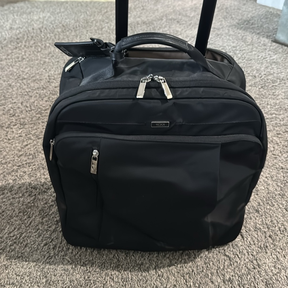 Tumi black luggage roller bag suitcasee briefcase.